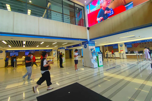 Bright hospital lobby with marble floors, service counters and digital kiosks inside — medical checkup china referral
