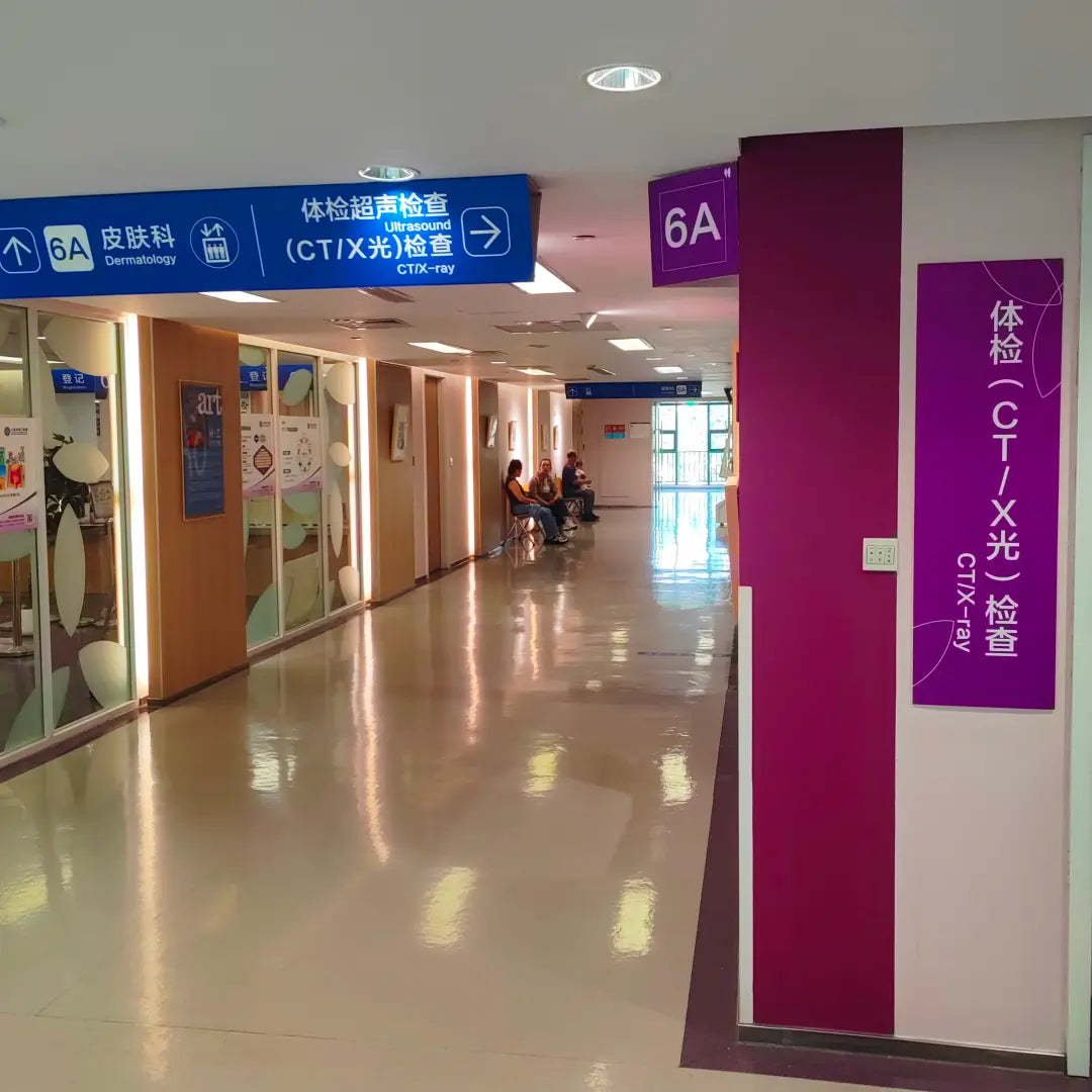 Hospital 6A floor corridor with directional signs for ultrasound, dermatology and CT/X-ray screening, used during health checkup visits at Shanghai Tongren Hospital